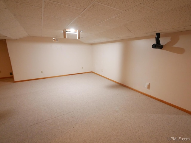 finished basement with carpet floors, a drop ceiling, and baseboards