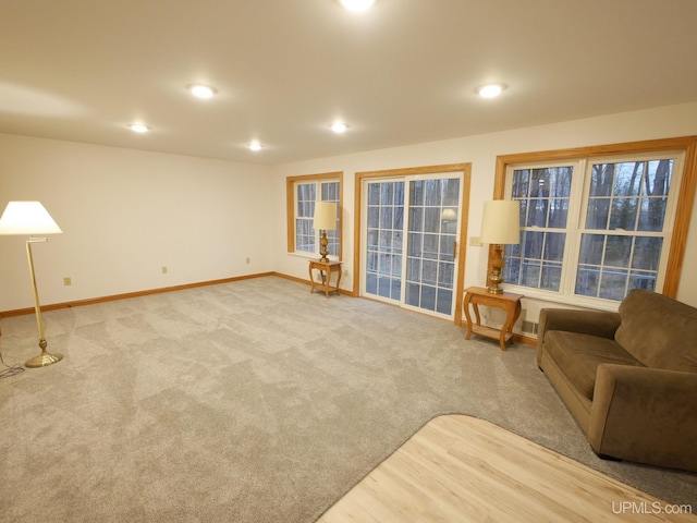 carpeted living area featuring baseboards and recessed lighting