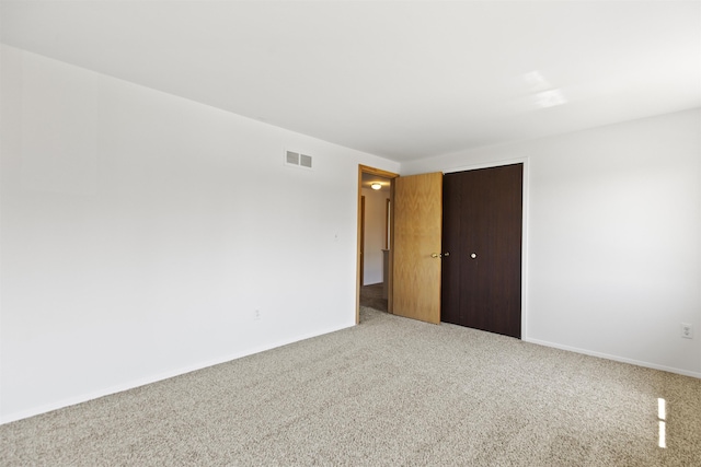 spare room featuring visible vents, carpet flooring, and baseboards