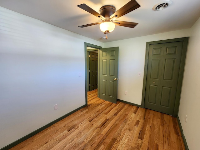 unfurnished bedroom featuring visible vents, light wood finished floors, baseboards, and a ceiling fan