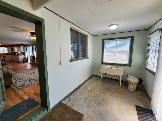 interior space with concrete flooring, baseboards, and a ceiling fan