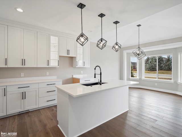 kitchen featuring a sink, a center island with sink, white cabinetry, dark wood-type flooring, and recessed lighting