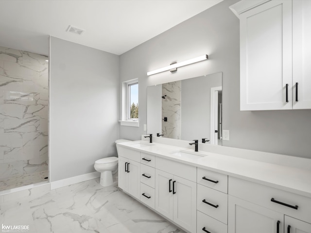 bathroom featuring marble finish floor, toilet, a sink, and a marble finish shower