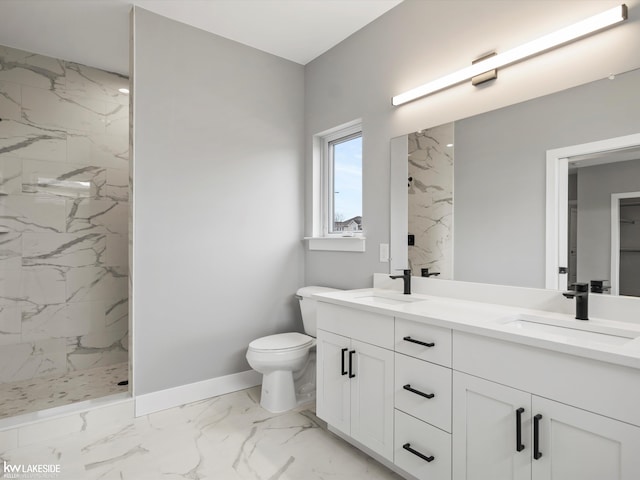 bathroom featuring a marble finish shower, marble finish floor, toilet, and a sink