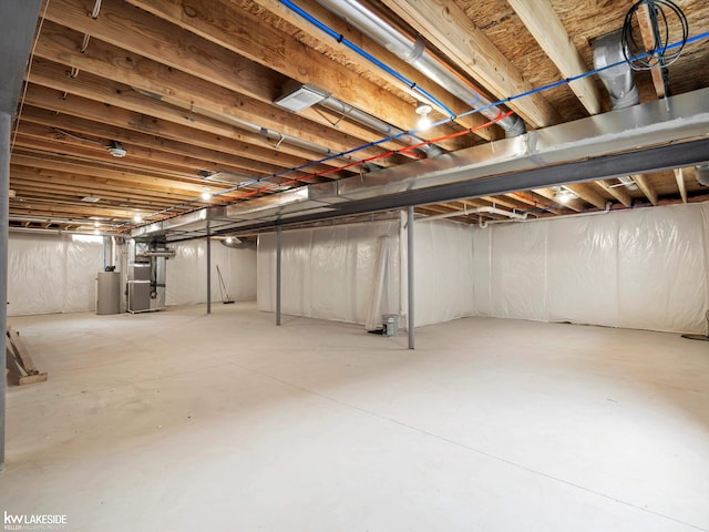 unfinished below grade area featuring gas water heater and heating unit