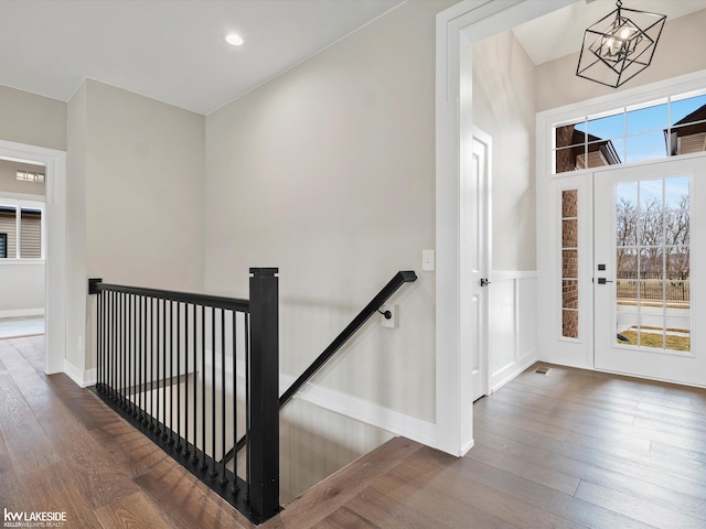 staircase with baseboards, an inviting chandelier, recessed lighting, and wood-type flooring