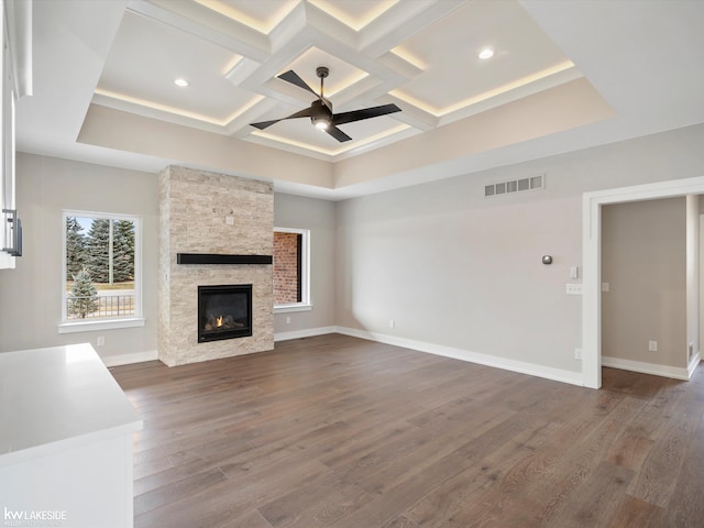 unfurnished living room with visible vents, coffered ceiling, wood finished floors, ceiling fan, and a fireplace