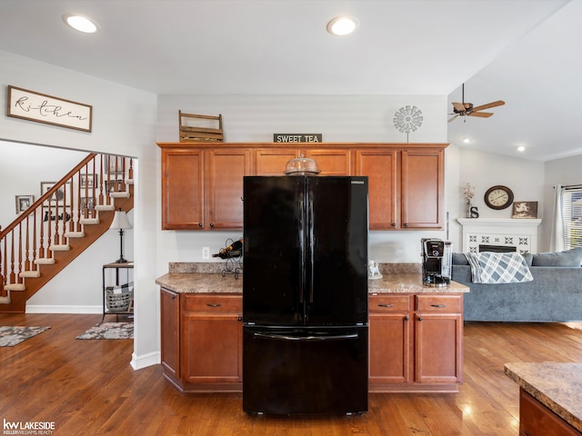 kitchen with dark wood-style floors, open floor plan, freestanding refrigerator, a ceiling fan, and brown cabinets