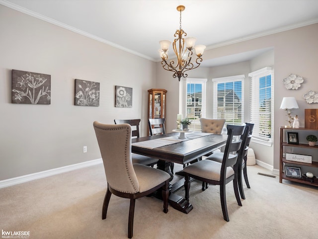 dining space featuring baseboards, an inviting chandelier, crown molding, and light carpet