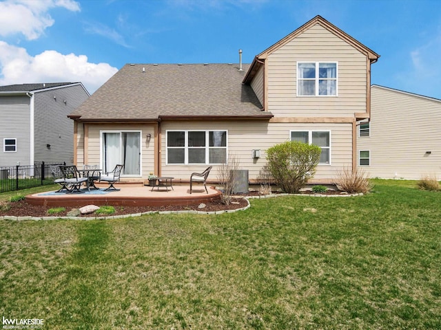 back of house with roof with shingles, central air condition unit, fence, a patio area, and a yard