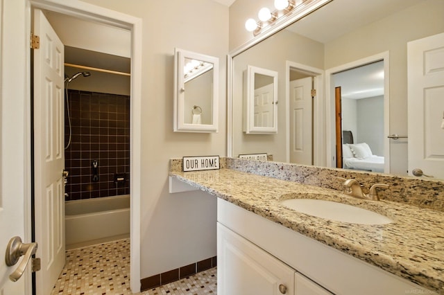 ensuite bathroom featuring vanity, baseboards, bathtub / shower combination, and connected bathroom