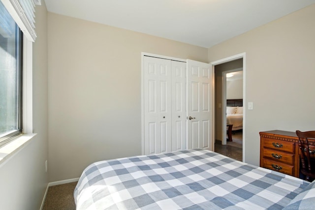 bedroom with baseboards, carpet floors, and a closet