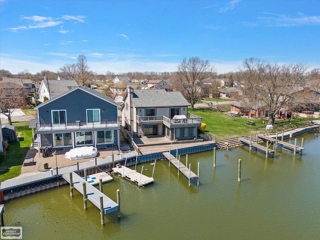 view of dock with a patio, a residential view, and a water view
