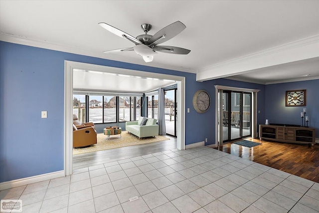 interior space with ceiling fan, baseboards, crown molding, and tile patterned floors