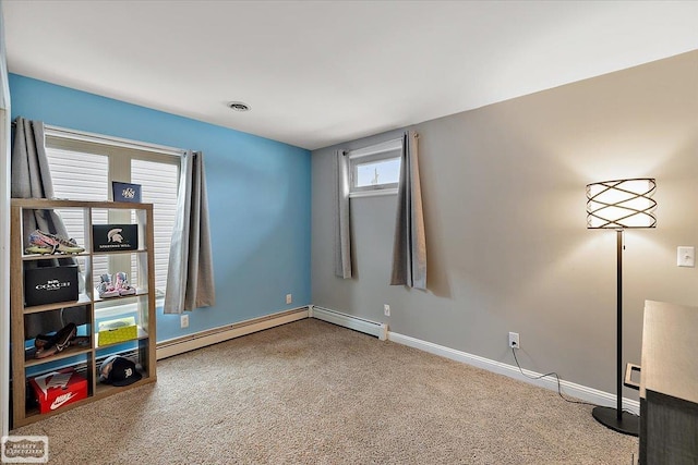 interior space featuring baseboard heating, carpet floors, visible vents, and baseboards