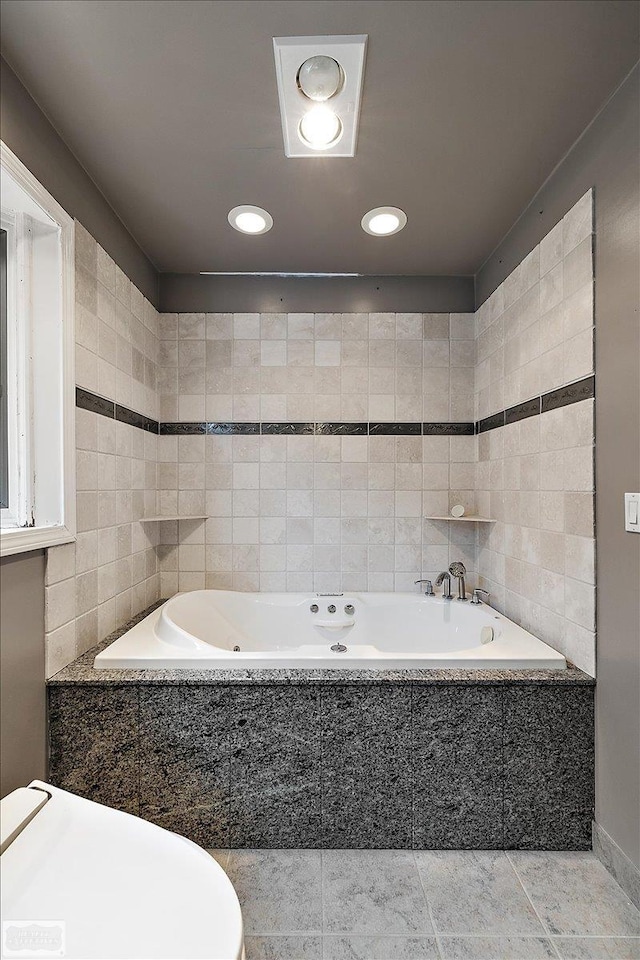 bathroom featuring recessed lighting, tile walls, tile patterned flooring, and a tub with jets