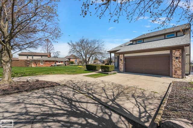 exterior space featuring stone siding, a yard, and concrete driveway