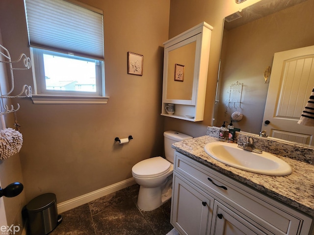 half bathroom with vanity, toilet, and baseboards