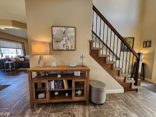 stairs featuring stone tile floors and baseboards