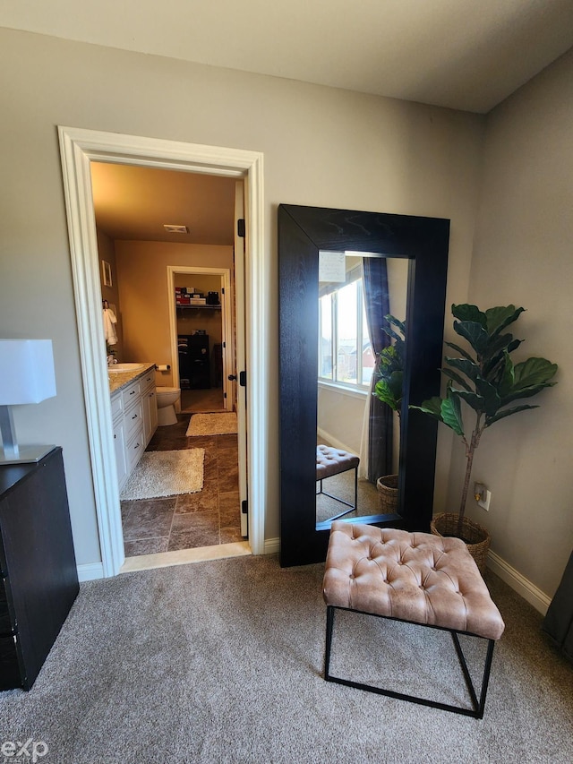 interior space with baseboards, dark colored carpet, and visible vents