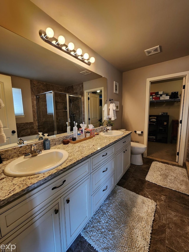 bathroom with visible vents, a sink, double vanity, and a stall shower