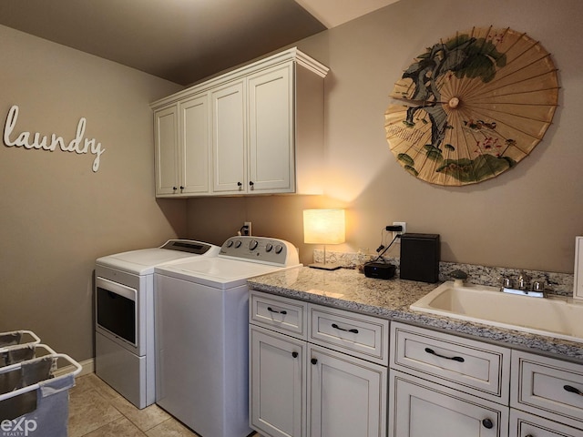 laundry area featuring a sink, independent washer and dryer, light tile patterned floors, and cabinet space