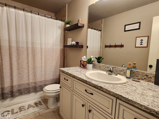 full bathroom with shower / tub combo with curtain, tile patterned flooring, vanity, and toilet