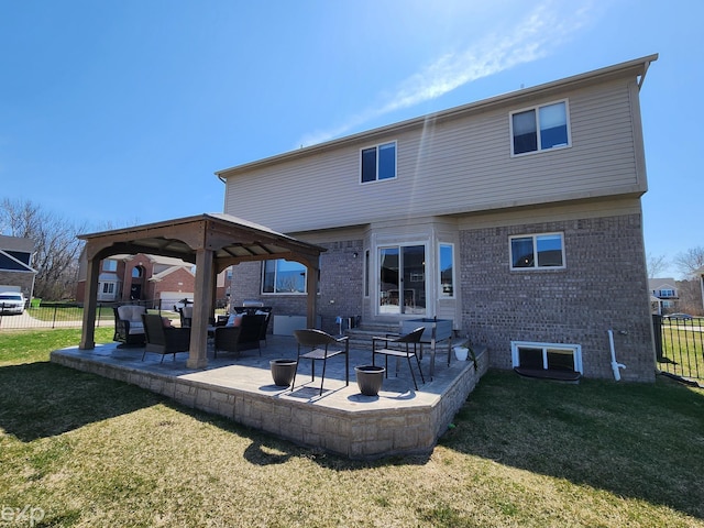 back of property with a gazebo, a lawn, and fence