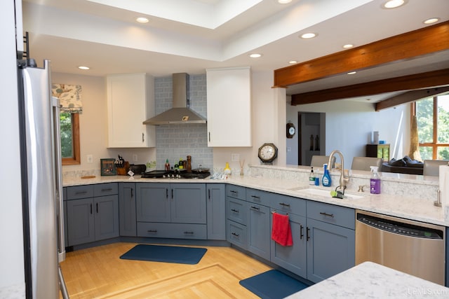 kitchen with stainless steel appliances, a sink, recessed lighting, white cabinetry, and wall chimney range hood