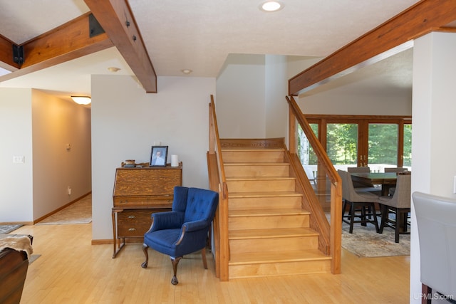 stairway with french doors, wood finished floors, beam ceiling, and recessed lighting