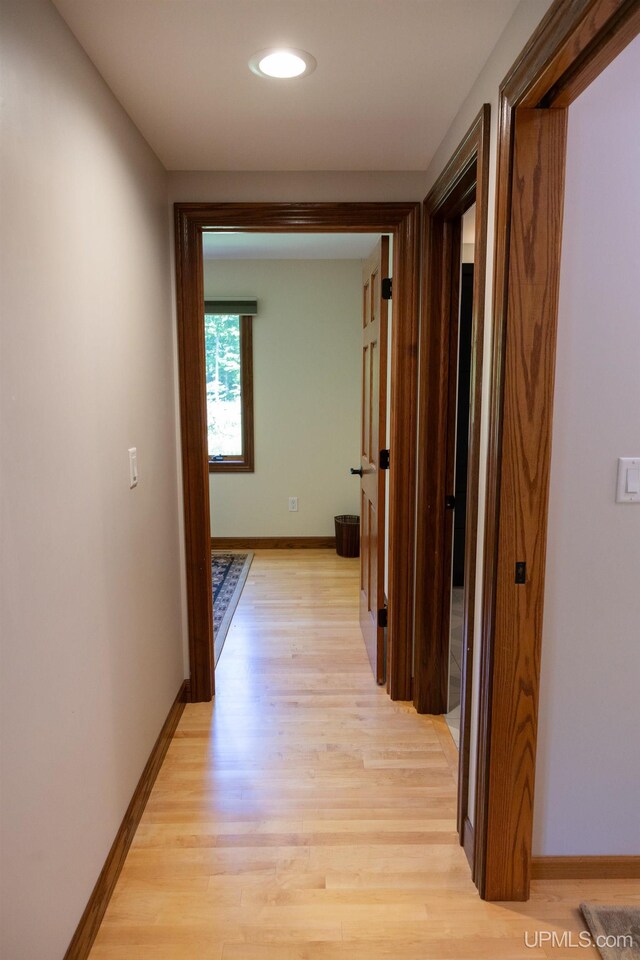 corridor with recessed lighting, light wood finished floors, and baseboards
