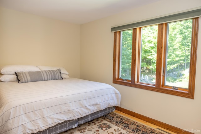 bedroom with wood finished floors and baseboards