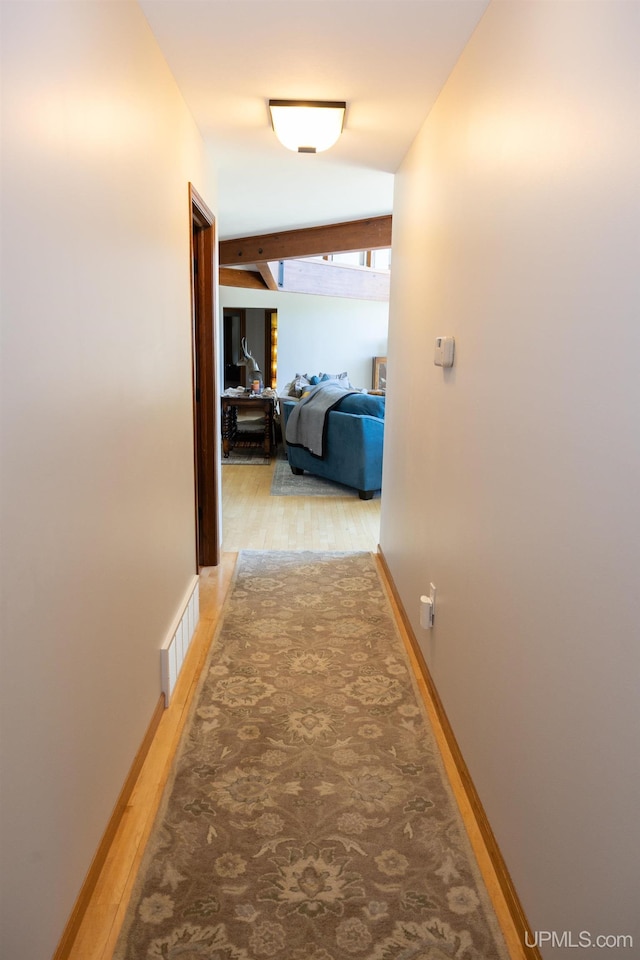 hall featuring baseboards and visible vents