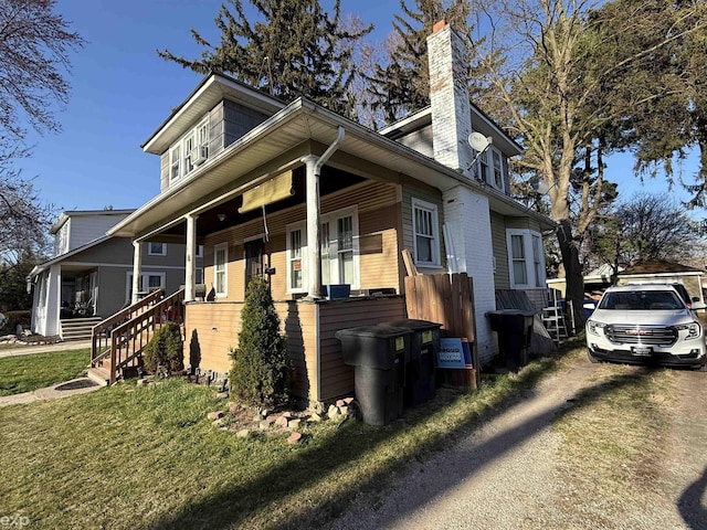 view of front of house featuring a chimney and covered porch