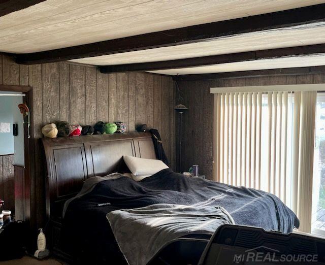 2255 E Sanilac Rd, Carsonville, MI 48419 - bedroom with wood walls, beamed ceiling, and carpet floors