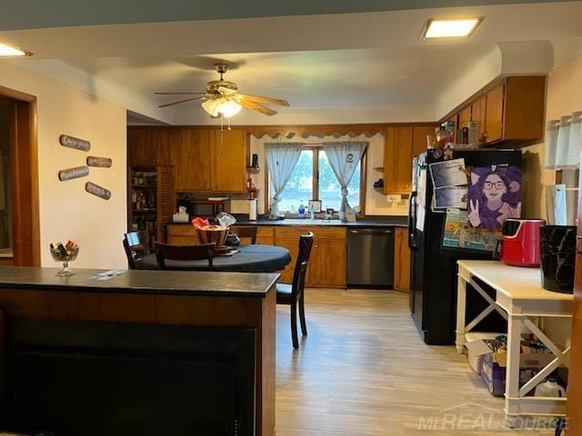 2255 E Sanilac Rd, Carsonville, MI 48419 - kitchen with stainless steel dishwasher, brown cabinetry, ceiling fan, light wood-style flooring, and dark countertops