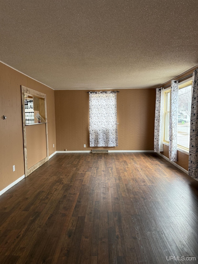 231 E Chocolay St, Munising, MI 49862 - spare room featuring baseboards, dark wood-style flooring, and a textured ceiling