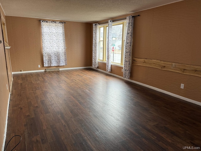 231 E Chocolay St, Munising, MI 49862 - unfurnished room with wood finished floors, a textured ceiling, and baseboards