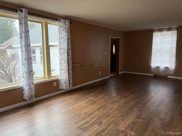 231 E Chocolay St, Munising, MI 49862 - unfurnished room with wood finished floors, a wealth of natural light, and a textured ceiling
