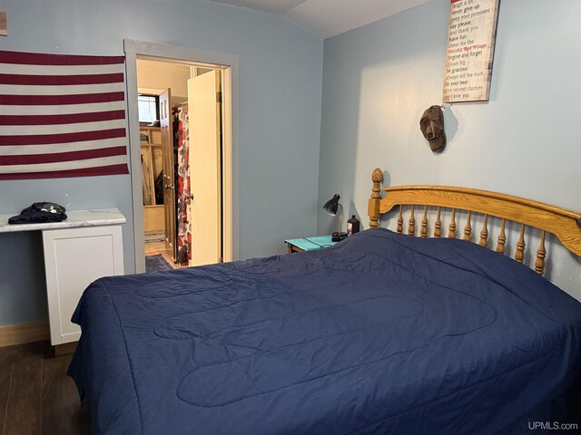 231 E Chocolay St, Munising, MI 49862 - bedroom featuring lofted ceiling, dark wood-type flooring, and baseboards