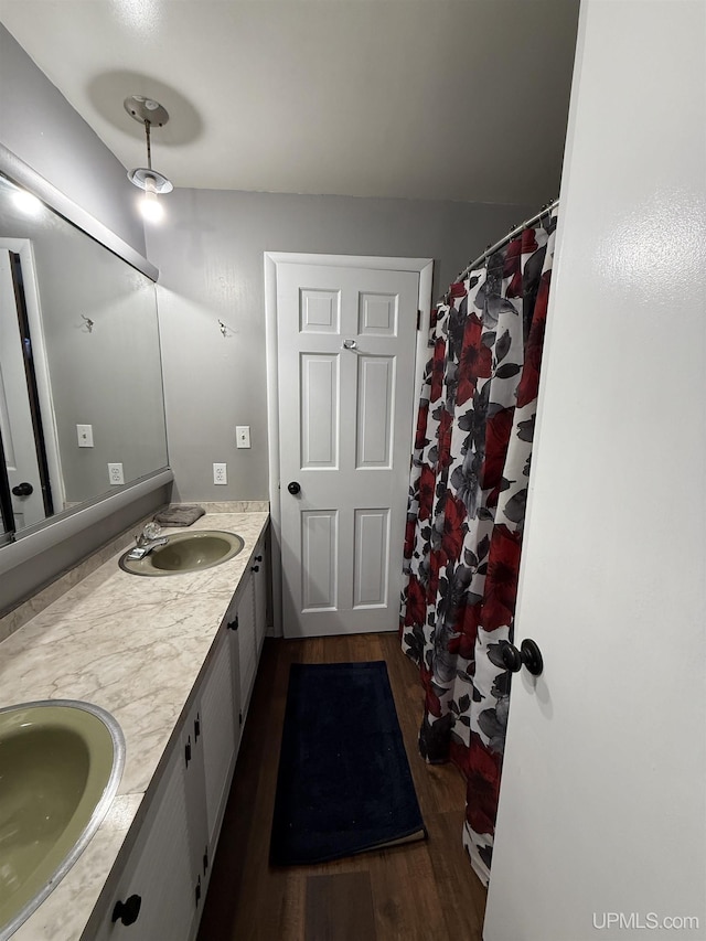 231 E Chocolay St, Munising, MI 49862 - full bathroom with wood finished floors, a sink, and double vanity
