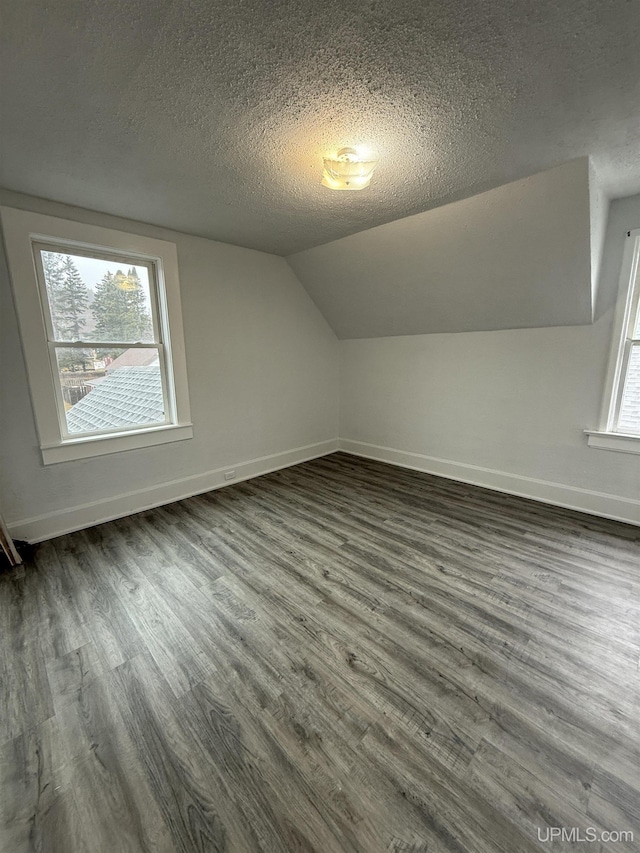 231 E Chocolay St, Munising, MI 49862 - bonus room featuring lofted ceiling, wood finished floors, baseboards, and a textured ceiling
