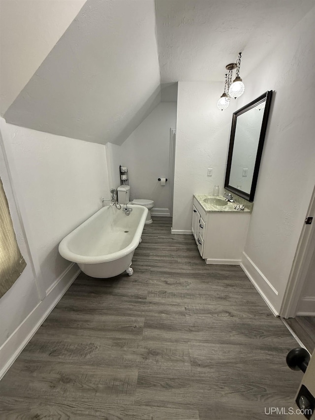 231 E Chocolay St, Munising, MI 49862 - full bathroom with lofted ceiling, wood finished floors, vanity, baseboards, and a freestanding tub