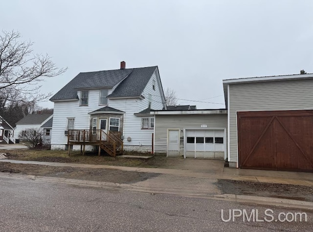 231 E Chocolay St, Munising, MI 49862 - view of front of home with a chimney, an attached garage, and driveway