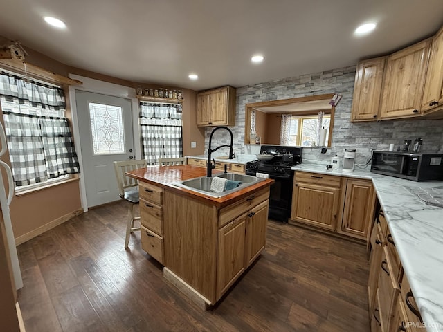231 E Chocolay St, Munising, MI 49862 - kitchen featuring dark wood-type flooring, tasteful backsplash, a sink, and black appliances
