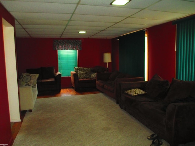 living area featuring carpet flooring and a drop ceiling