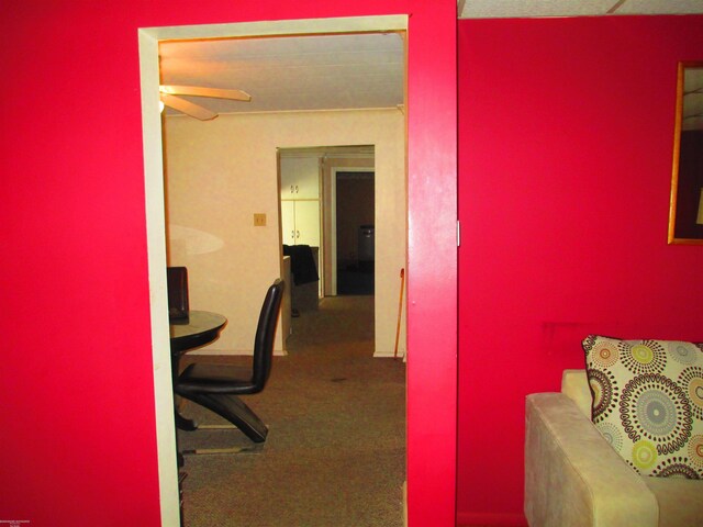 carpeted office space with a ceiling fan