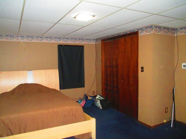 unfurnished bedroom featuring carpet and a drop ceiling