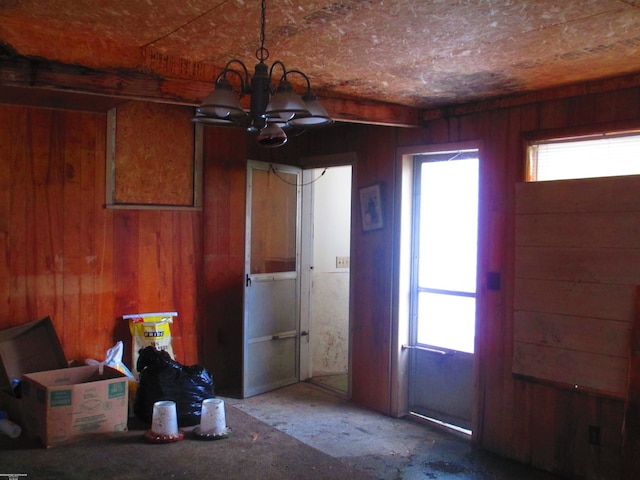 interior space featuring a chandelier and wooden walls