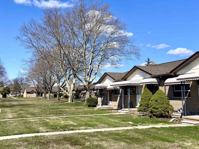 exterior space with a front lawn and brick siding
